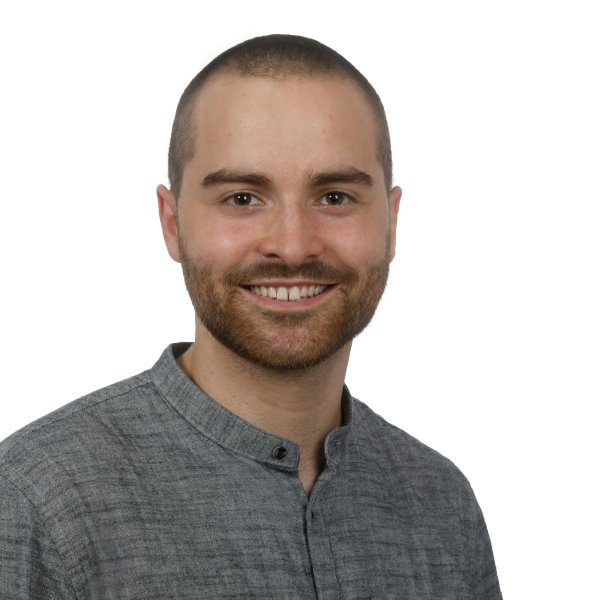 Portaitbild eines lächelnden jungen Mannes mit dunklen kurzen Haaren und grauem Hemd