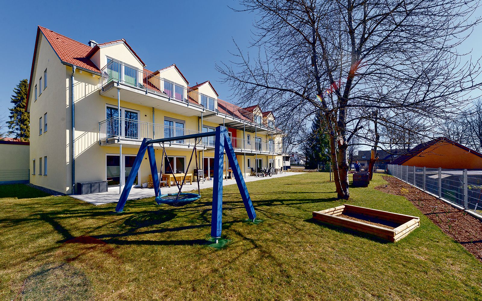 Das Gebäude der Außenwohngruppe des Blindeninstituts Regensburg in Hemau mit einem Spielplatz direkt am Haus. Hier lebt Marilyn.