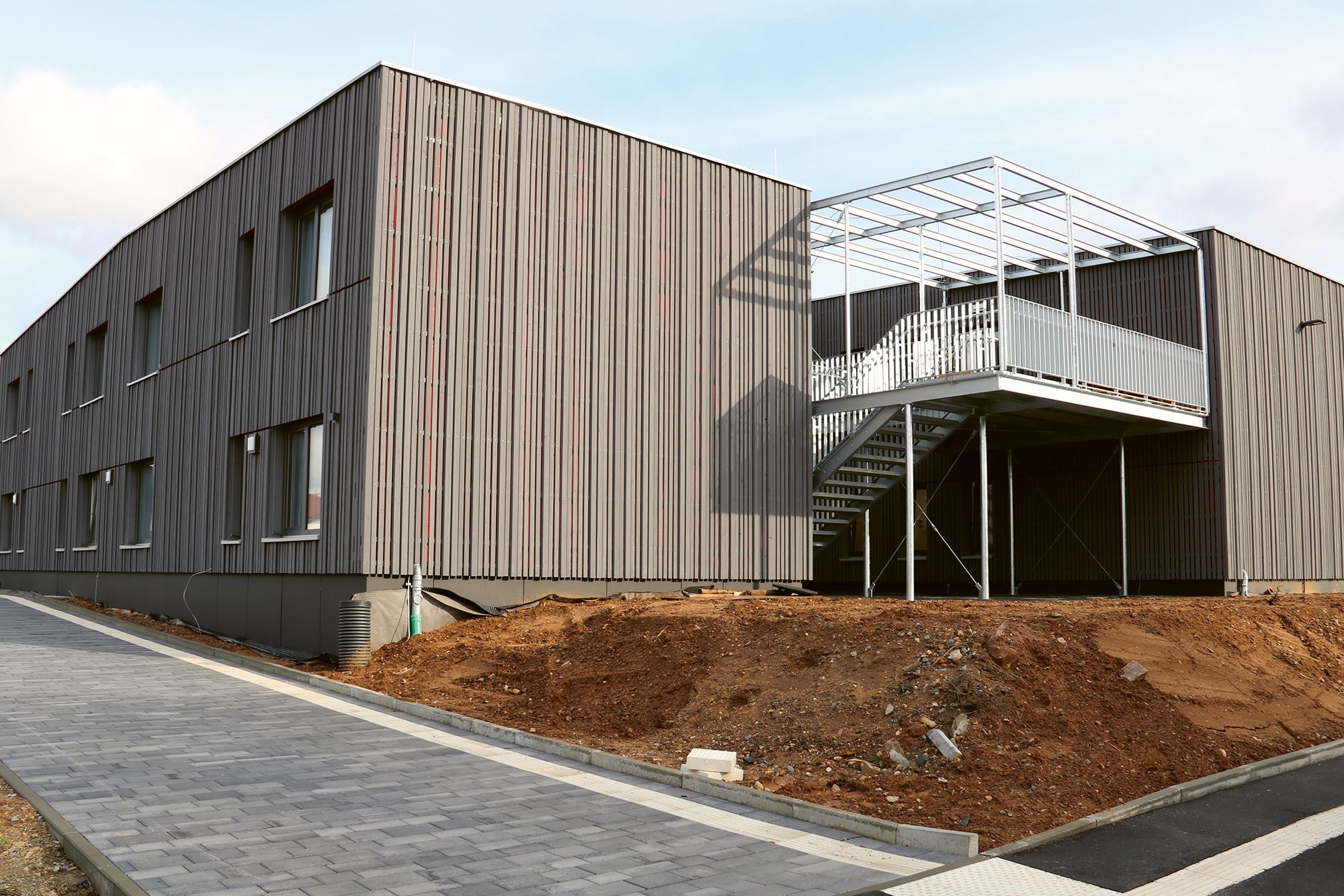 Bild 1: Außenansicht des neuen Blindeninstitut Kitzingen. Die Fassade ist braun.
