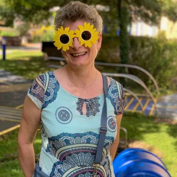 Auf dem Bild sieht man eine Frau mit einer Sonnenblumen-SOnnenbrille