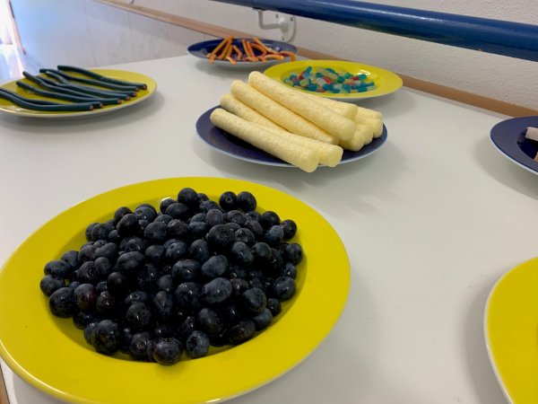 auf dem Bild sieht man Blaubeeren, Pufoletti und weiteres Essen in blauer oder gelber Farbe
