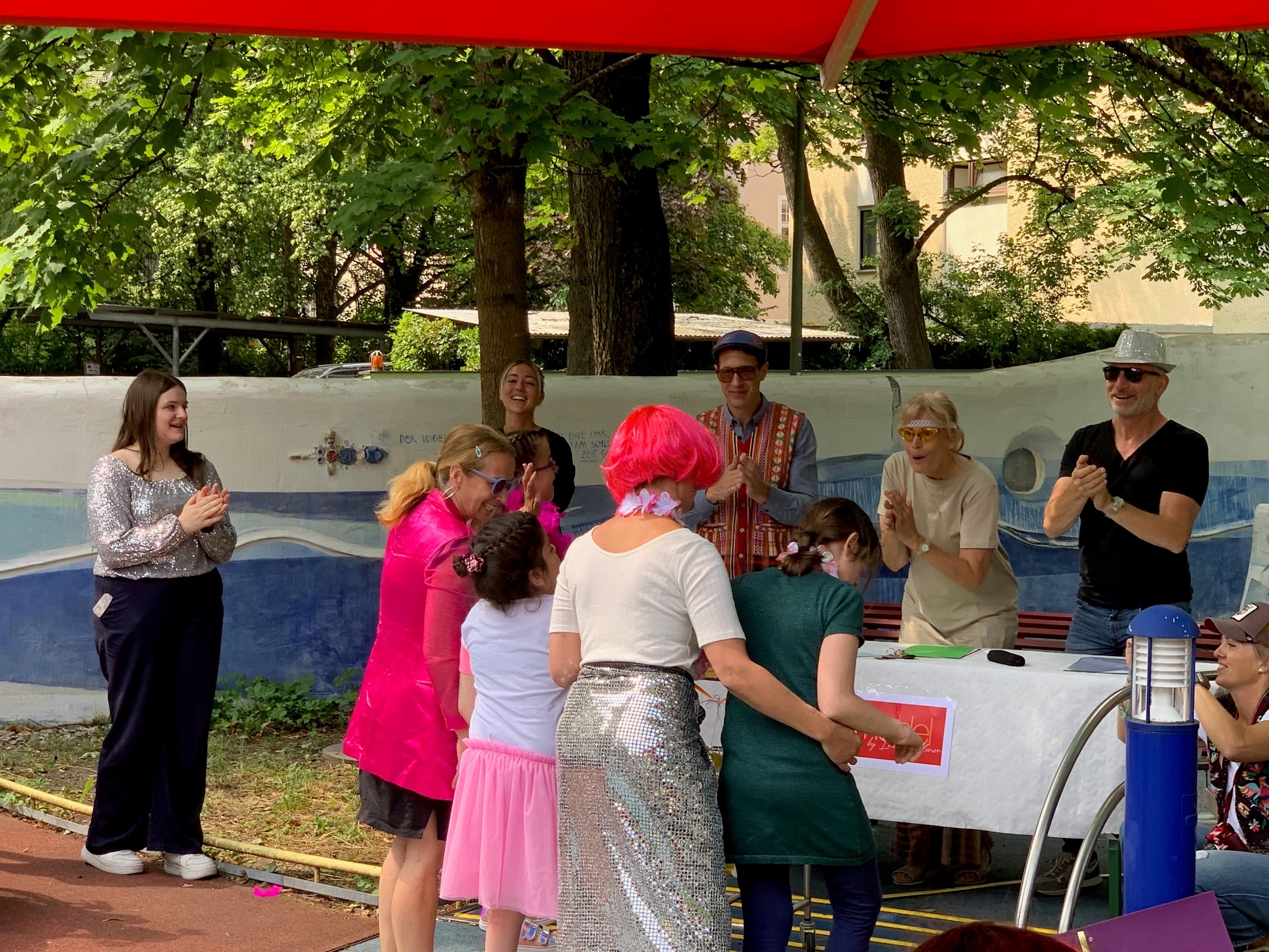 Auf dem Bild sieht man mehrere Personen beim Topmodelwettbewerb - sowohl Jury als auch Teilnehmende