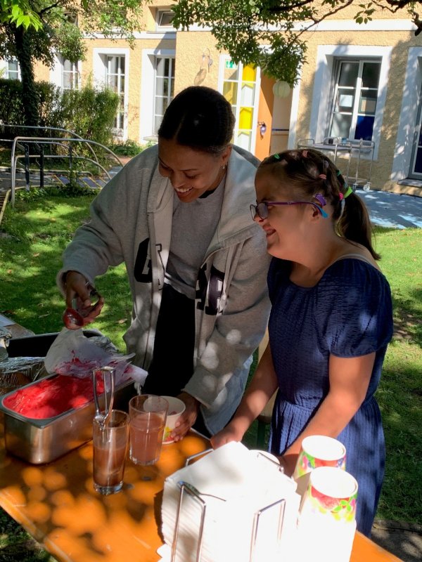 Auf dem Bild sieht man wie eine Frau einem Mädchen ein Eis macht