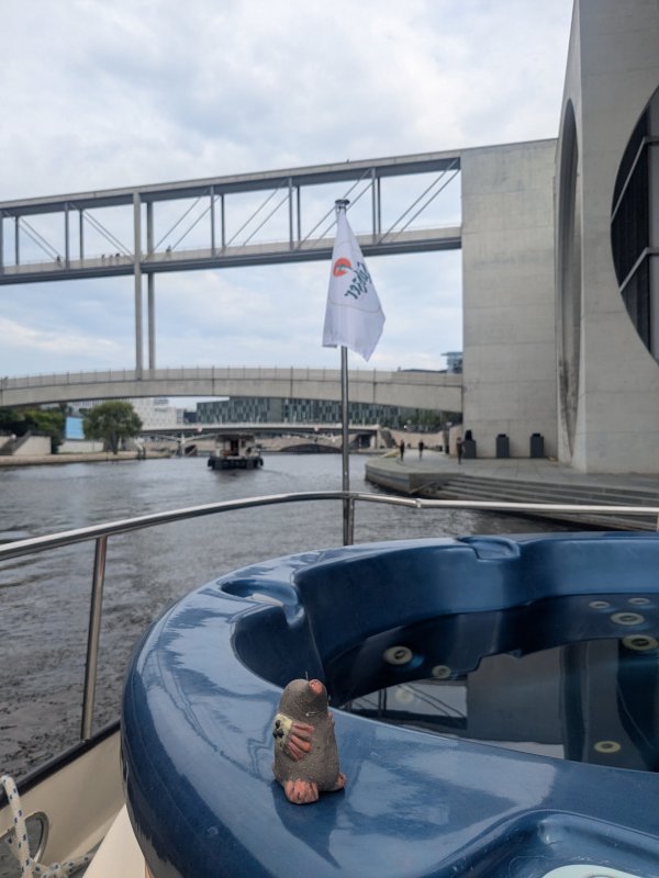 Auf dem Bild sieht man einen kleinen Maulwurf aus Ton, der auf einem Boot in Berlin fährt.