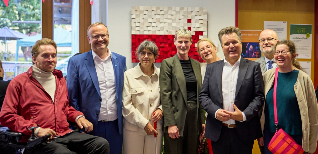 Gruppen Foto von 8 Personen die alle in die Kamera gucken