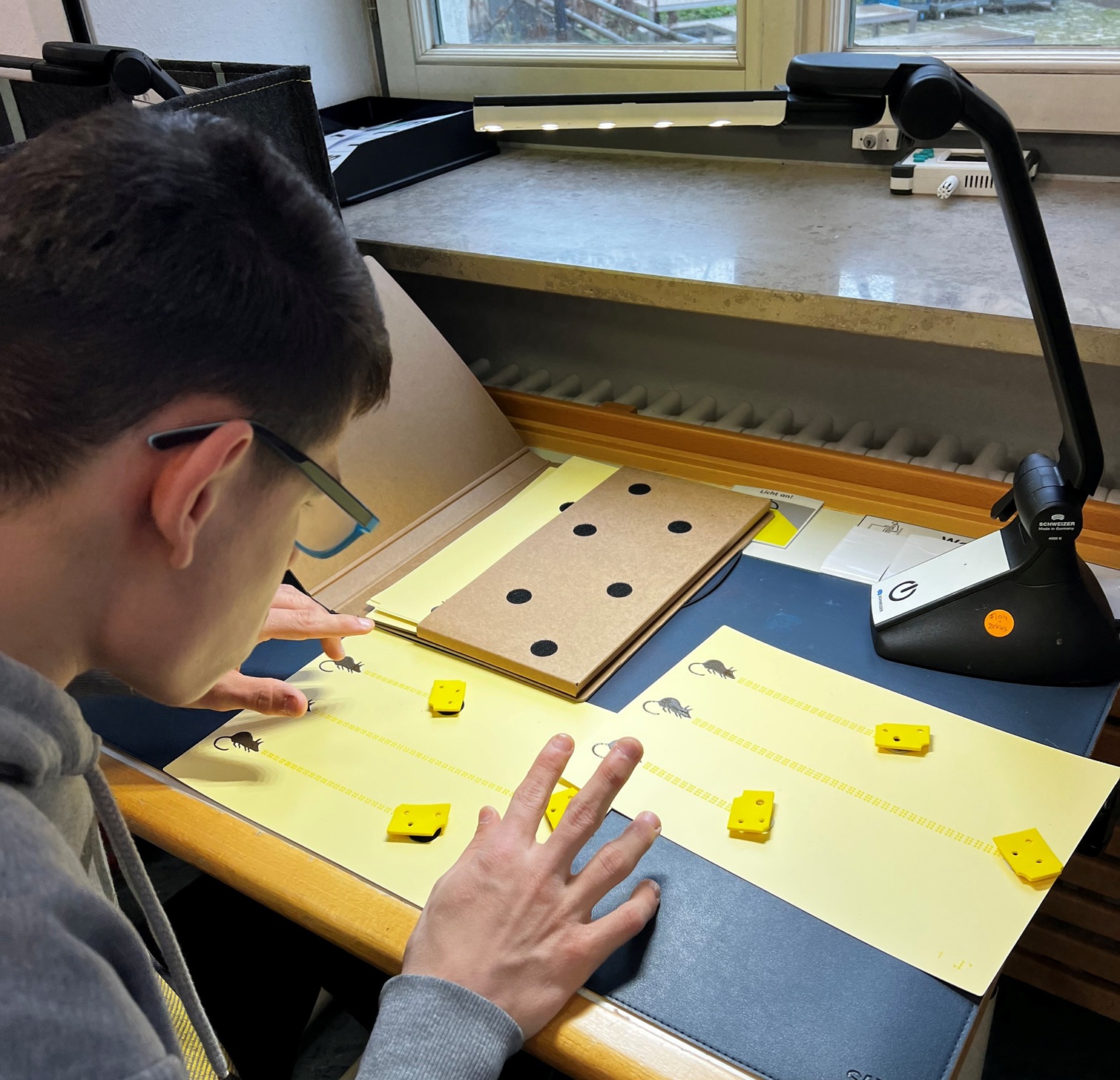 Auf dem Bild sieht man einen Jungen, der Brailleschrift liest
