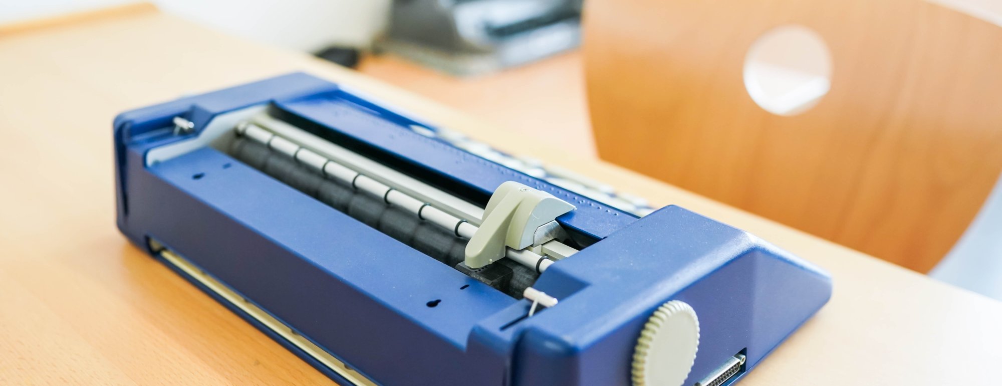Eine Braille-Schreibmaschine steht auf einem Tisch.