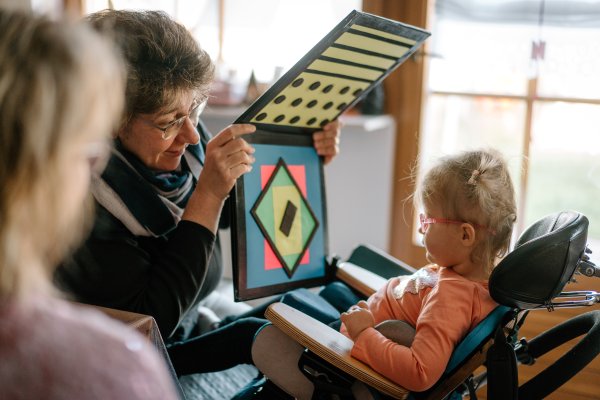 Eine Frau präsentiert einem jungen Mädchen optische Muster.