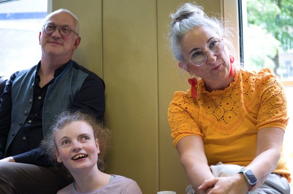 Auf dem Bild sieht man drei Menschen, die den Musiker*innen des BSRO lauschen