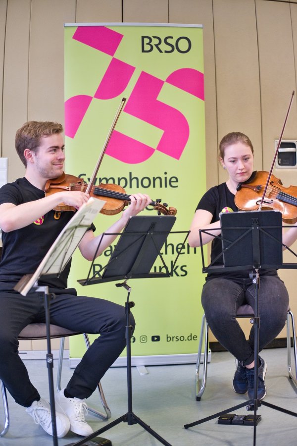 Das Bild zeigt zwei Musiker*innen des BRSO, die auf der Geige spielen