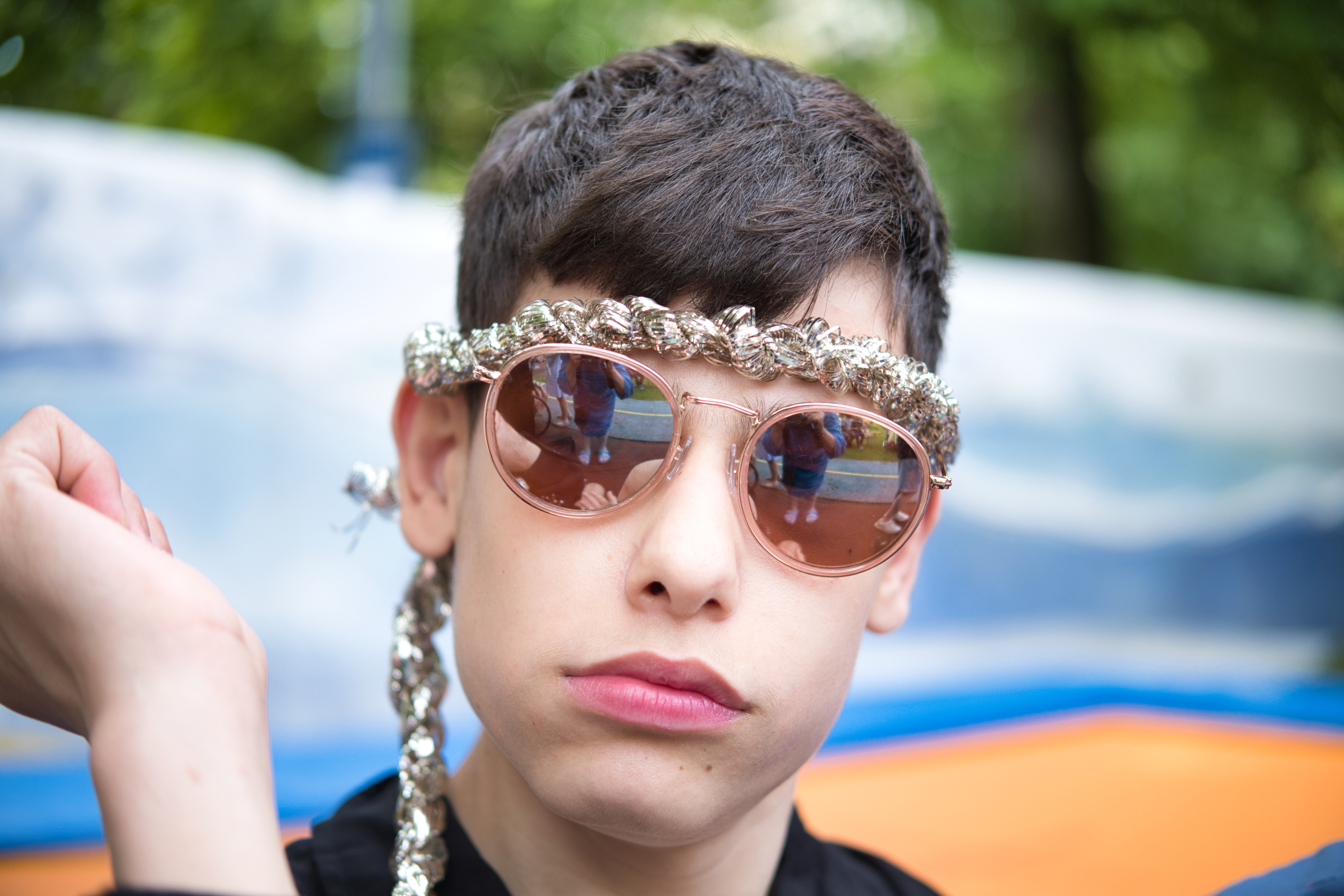 Auf dem Bild sieht man einen Jungen mit Sonnenbrille