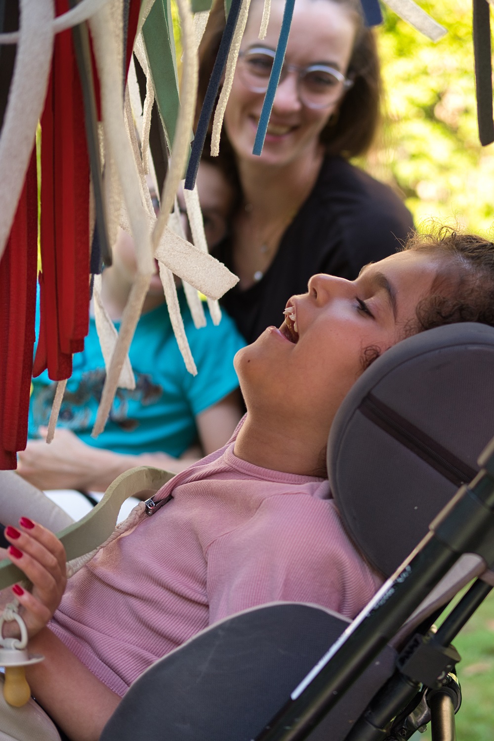 Das Bild zeigt ein Mädchen und eine Frau neben bunten Plastikschlangen