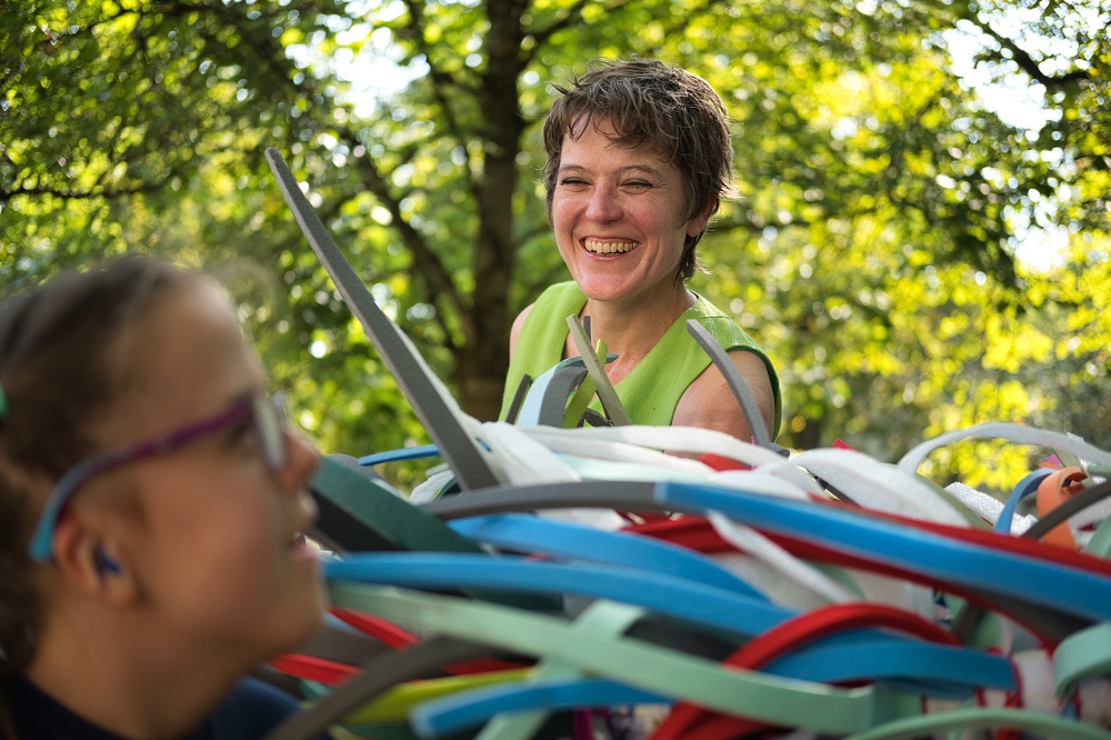 Das Bild zeigt ein Mädchen und eine Frau neben bunten Plastikschlangen.