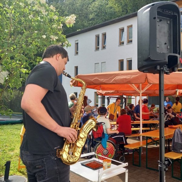 Felix spielt vor eine Gruppe Bewohnen auf seinem Saxophon