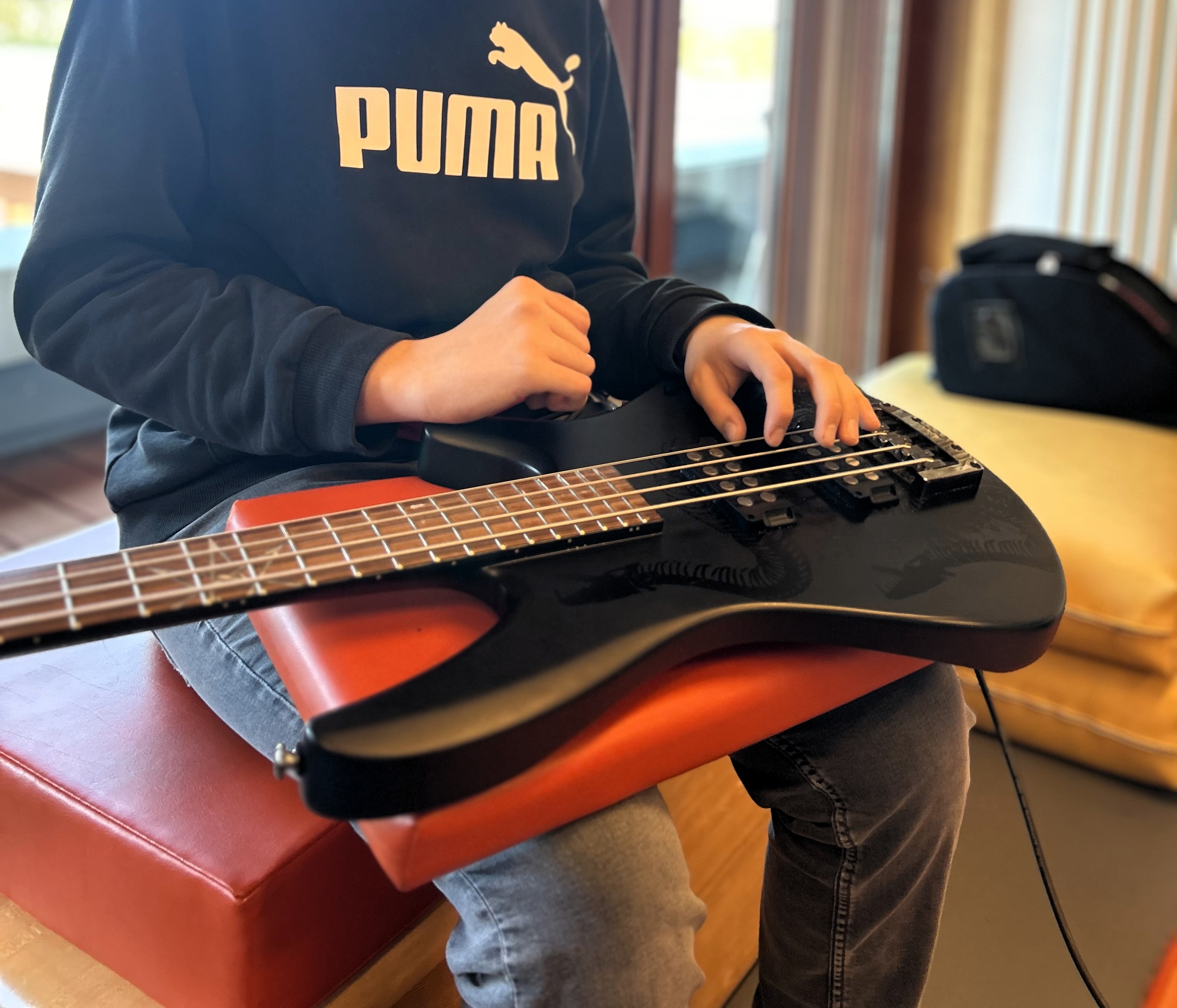 Ein Schüler in der Musiktherapie, mit einer E-Gitarre