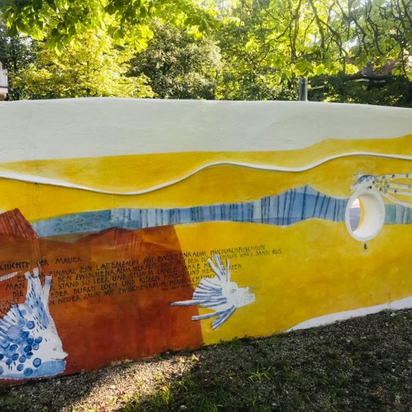 Das Bild zeigt einen Teil der Mauer des Spielplatzes des Blindeninstituts München.