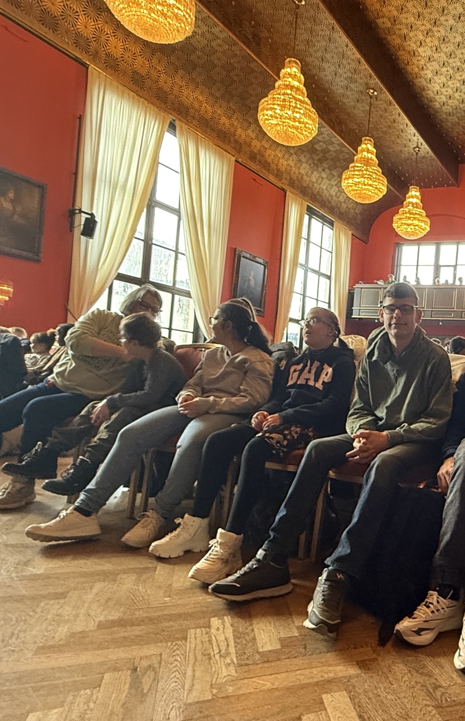 auf dem Bild sieht man Kinder und Jugendliche auf Stühlen in einem Zuschauerraum.