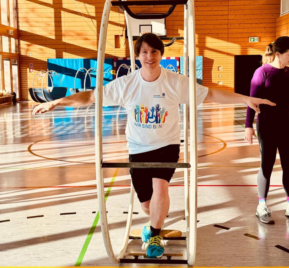 Auf dem Bild sieht man einen jungen Mann im Rhönrad