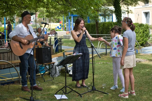 Das Bild zeigt Konzertbesucher und Musiker im Garten des Blindeninsituts München