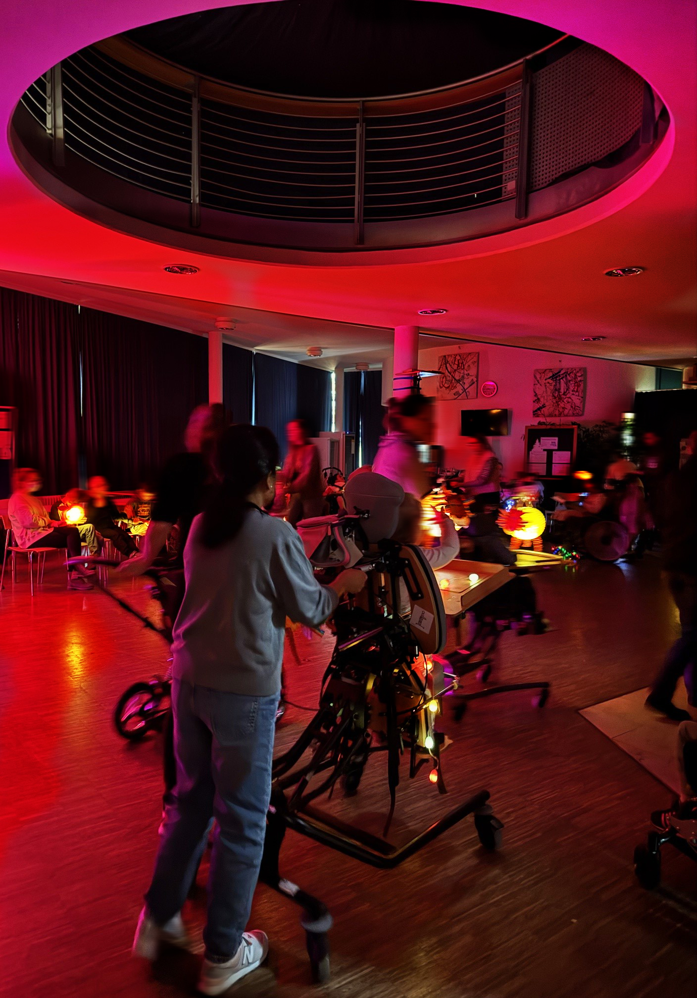 Auf dem Bild ist die abgedunkelte Aula mit hellerstrahlten Laternen und ihre stolzen Besitzer*innen zu sehen. Die Kinder ziehen Ihre Runden zu der Musik.