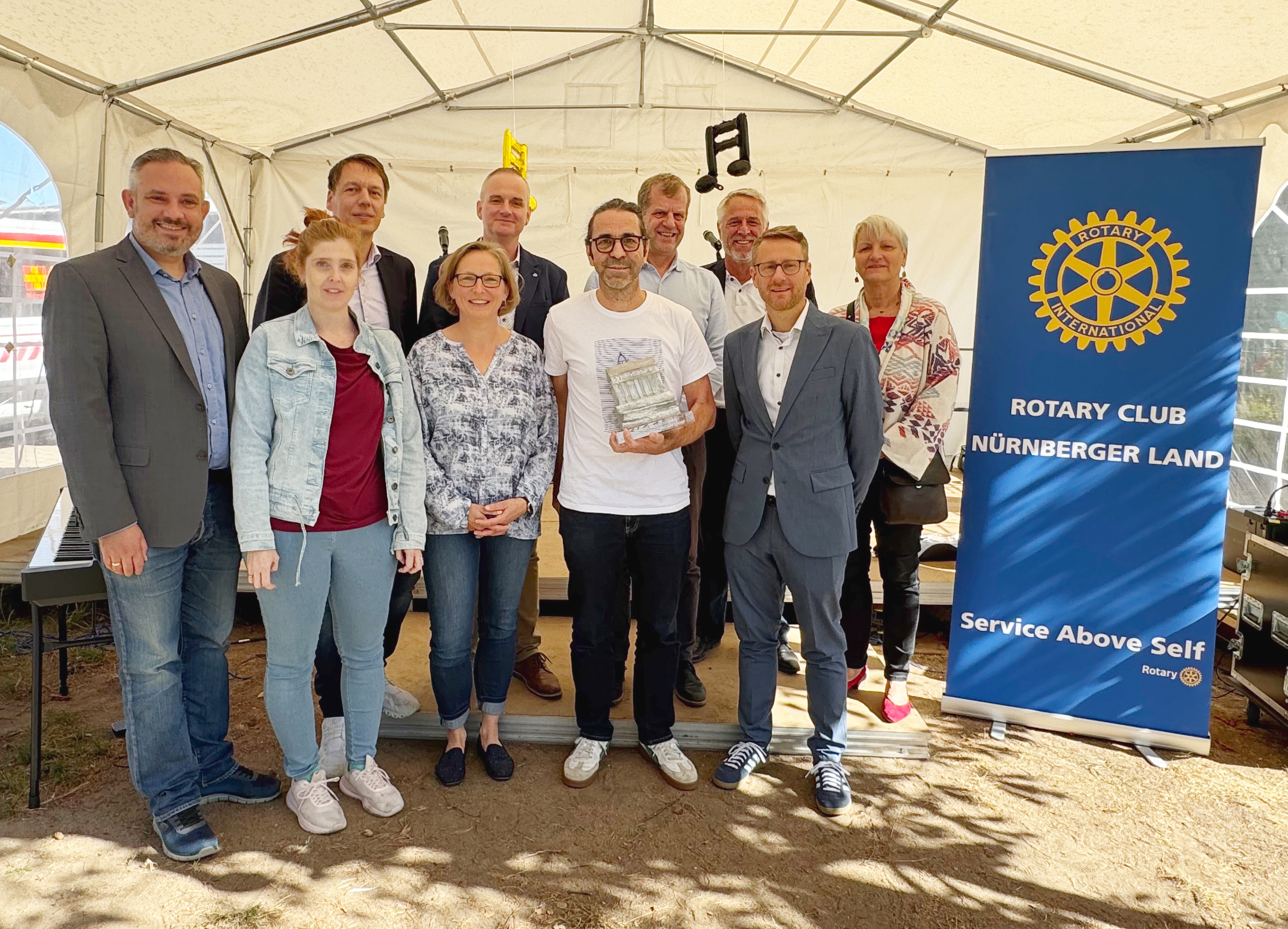 Landrat Markus Gleißenberg, Vertreterinnen des Elternbeirats, Institutsleiter Dominic Weufen, Preisträger Torsten Nowitzki, Zweiter Bürgermeister Alexander von Ciriacy-Wantrup sowie die Vertreterinnen des Rotary Clubs Nürnberger Land neben einem Banner des RC Nürnberger Land