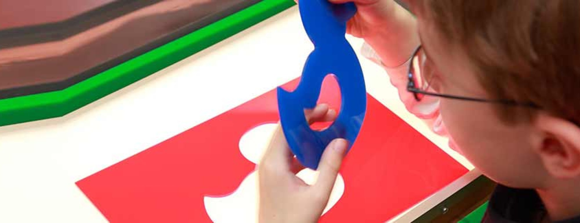 Das Bild zeigt einen jungen Menschen beim Fühlen einer Form.