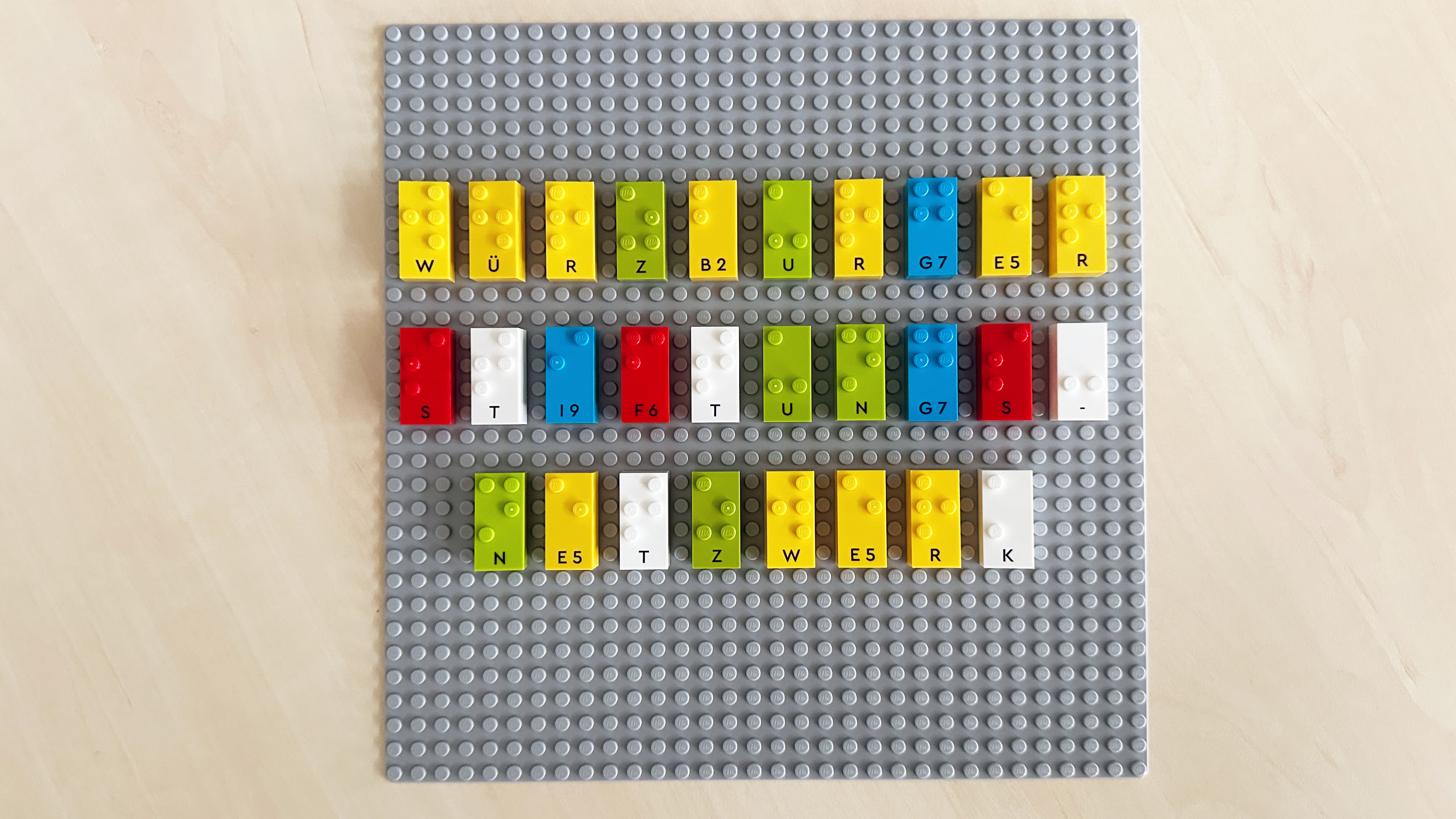 Lego-Steine mit Blindenschrift-Buchstaben die das Wort „Würzburger Stiftungsnetzwerk“ ergeben.