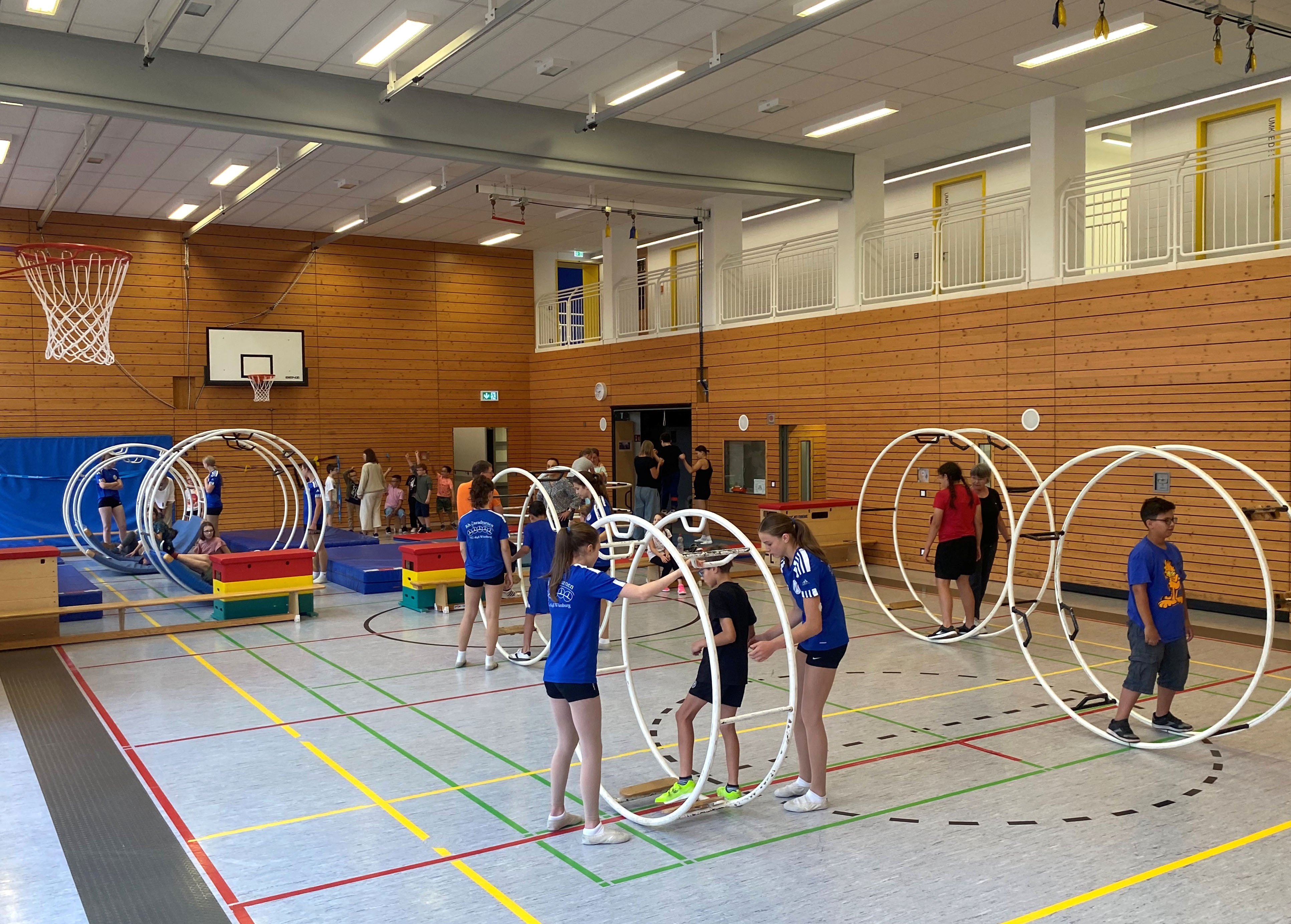 Eine Turnhalle mit Rhönrädern und Schülerinnen