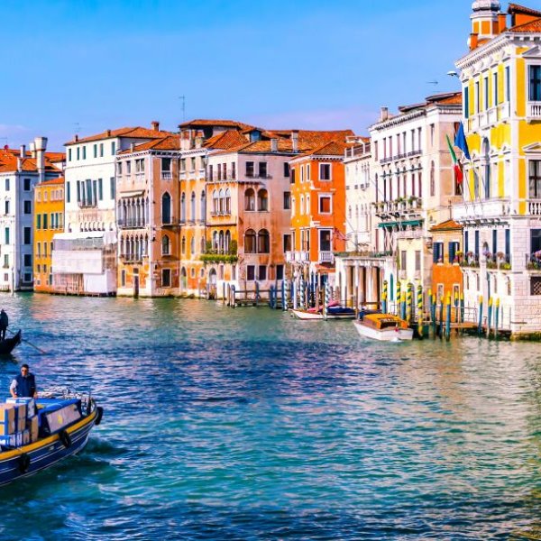 Auf dem Bild sieht man Venedig, ein paar Häuser, Wasser und Gondeln.