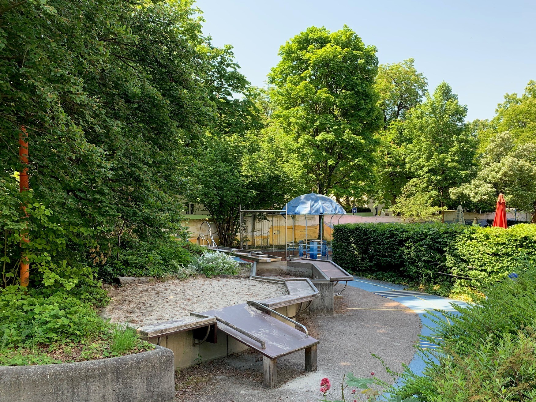 Auf dem Bild sieht man den Garten des Blindeninstituts München. Unte r anderem den Wasserspielplatz und die gelbe Mauer