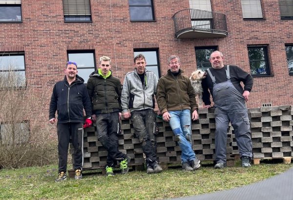 Helfer sortieren Pflastersteine für das Gartenprojekt