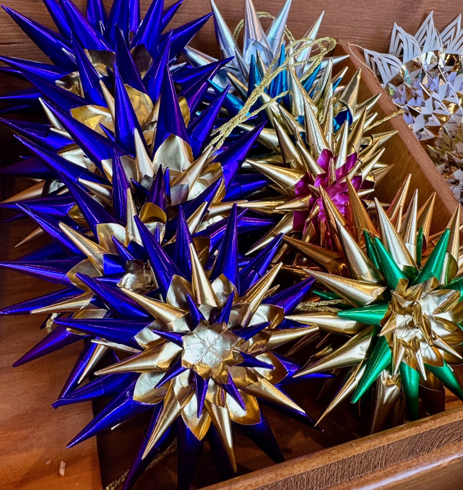 Kunstvolle Sterne aus Goldpapier und metallischglänzenden Farben.