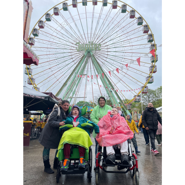 Zwei Kinder aus dem Blindeninstitut Rückersdorf mit zwei Mitarbeiterinnen vor dem Riesenrad auf dem Volksfest.