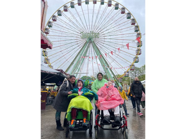 Zwei Kinder aus dem Blindeninstitut Rückersdorf mit zwei Mitarbeiterinnen vor dem Riesenrad auf dem Volksfest.