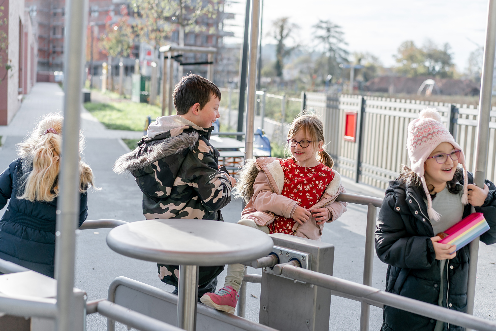 Vier Kinder spielen auf einem Rollstuhlkarussell.