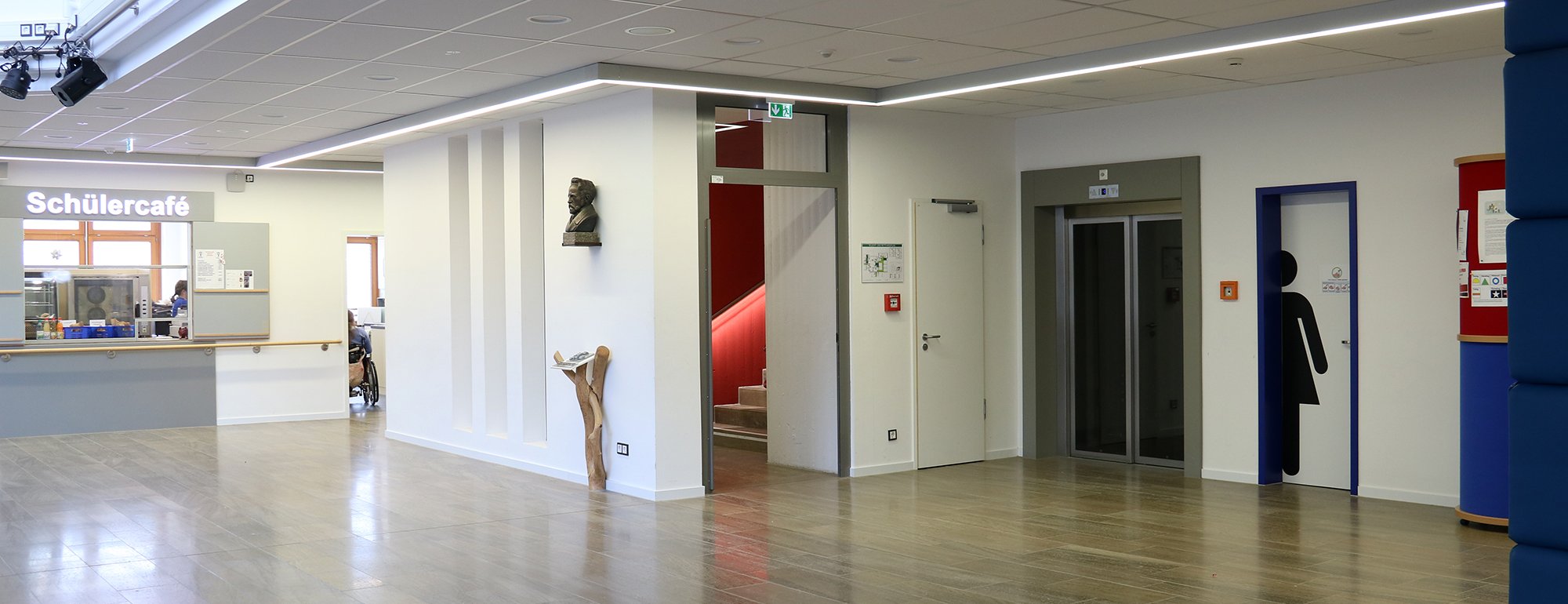 Ein Blick in die Aula der Schule mit Schülercafe im Hintergrund