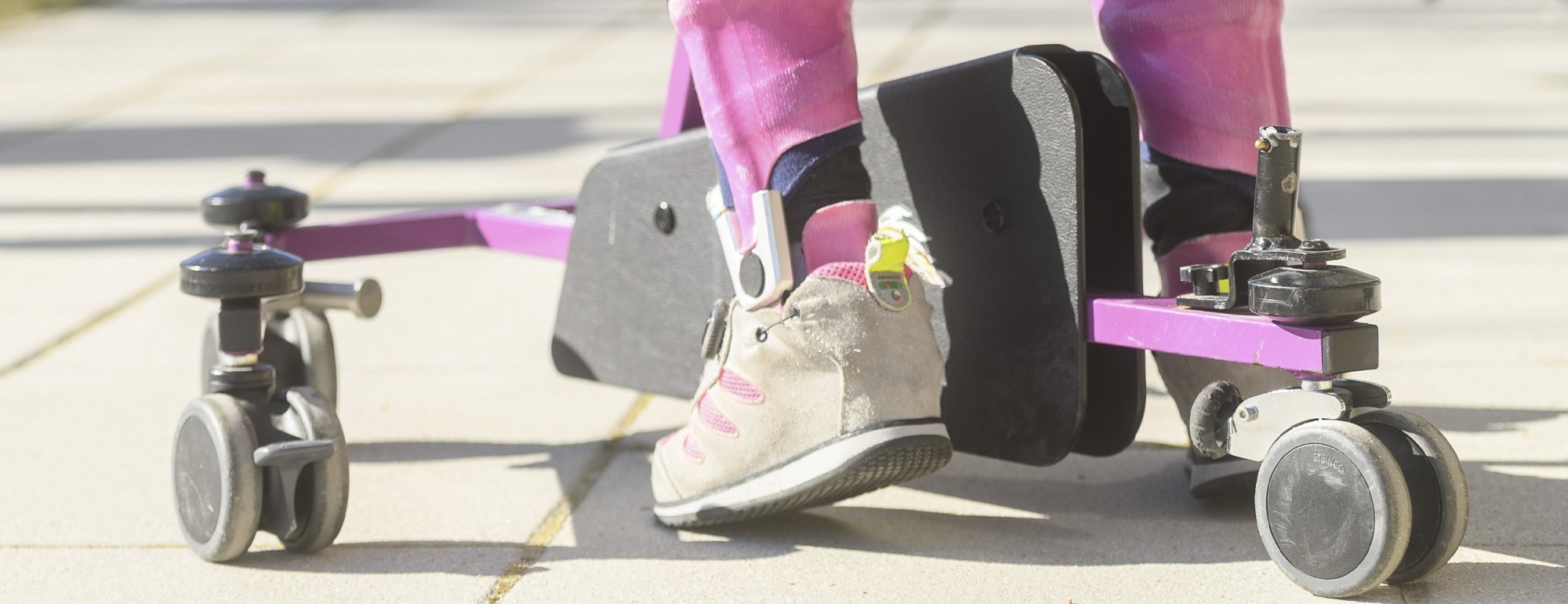 Ein Mädchen läuft mithilfe einer Gehhilfe.