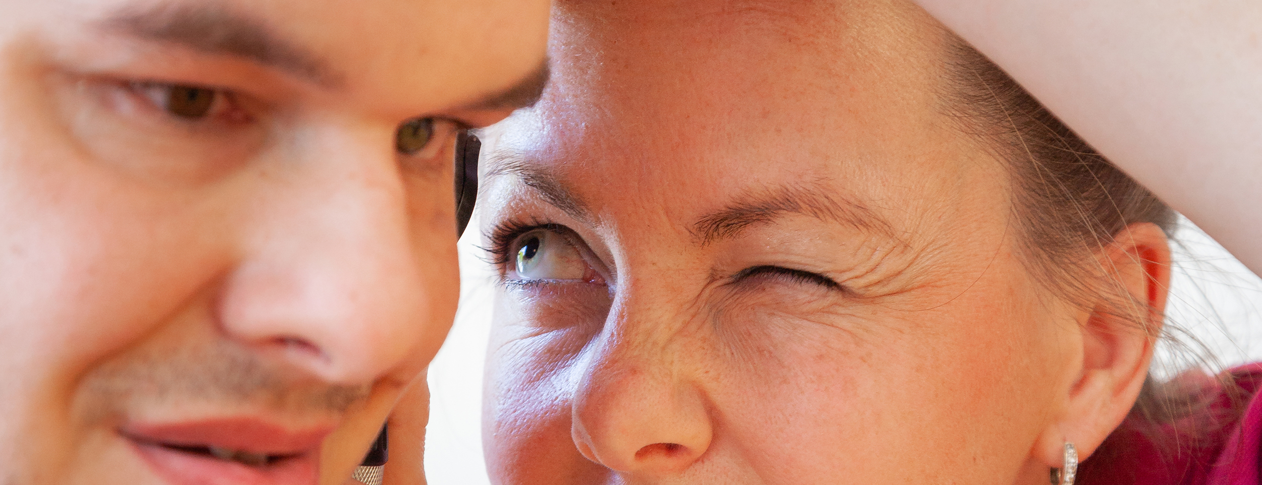 Eine Frau untersucht das Ohr eines Patienten.