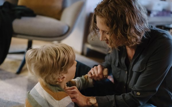 Ein Junge und eine Frau verständigen sich über ihre Hände.